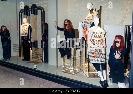 Gli ambientalisti di Extinction Rebellion si sono incollati alla vetrina del negozio Zara durante il Black Friday in segno di protesta contro il consumismo che uccide il pianeta. Vetrina del negozio Zara. Le parole: "Fast fashion kill" sono scritte sul bicchiere. All'interno, quattro persone sono incollate alla finestra, così come manichini con striscioni: Una T-shirt costa 1.700 litri d'acqua, uccisioni veloci e la maggior parte dei vestiti va direttamente nella spazzatura. Varsavia Polonia Copyright: XMikolajxJaneczekx Foto Stock