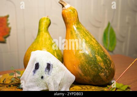 Natura morta autunnale. Zucche e un fantasma di tessuto. Foto Stock