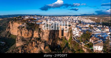 Ronda, in Spagna, è visibile dall'alto al tramonto, con il ponte Puente Nuevo su una profonda gola, edifici imbiancati e una suggestiva posizione sulla scogliera Foto Stock