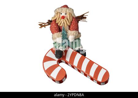 Babbo Natale, da favola, regge un albero di Natale e si arrampica su un gigantesco bastone di caramelle. È vestito con cappello di pelliccia, vestito rosso e verde e ha una barba filata per divertirsi. Foto Stock