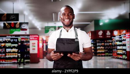 Dipendente apprendista del supermercato. Happy Man al negozio di alimentari Foto Stock