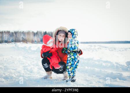 Famiglia felice che ama la giornata invernale all'aperto in un paesaggio innevato Foto Stock