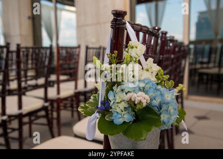 Eleganti fiori per matrimoni in blu alla fine delle sedie per cerimonie Foto Stock