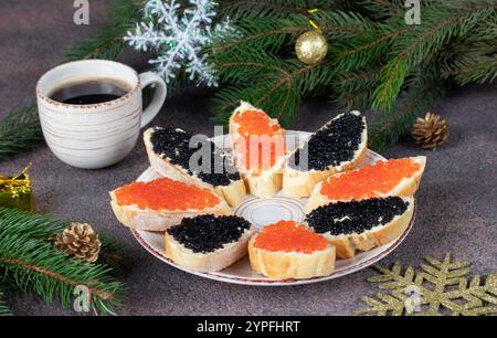 Panini fatti in casa con caviale rosso e nero su pane bianco tostato su piatto rotondo Foto Stock