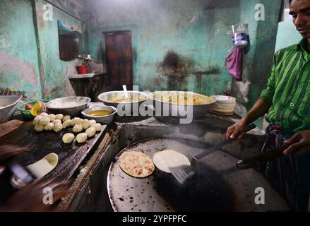 Un uomo bengalese che prepara roti freschi in un piccolo ristorante a Dacca, Bangladesh. Foto Stock