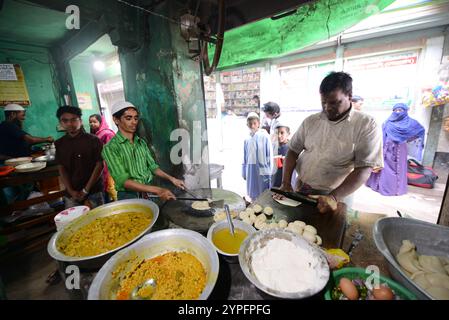 Un uomo bengalese che prepara roti freschi in un piccolo ristorante a Dacca, Bangladesh. Foto Stock