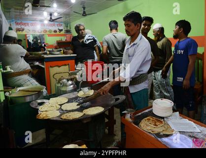 Un uomo bengalese che prepara roti freschi in un piccolo ristorante a Dacca, Bangladesh. Foto Stock