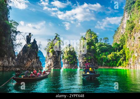 Gruppo di viaggiatori avventurosi in barca gioia la splendida natura paesaggio panoramico del parco nazionale di Khao Sok, incredibile punto di riferimento viaggio in Thailandia, gente turistica su Foto Stock