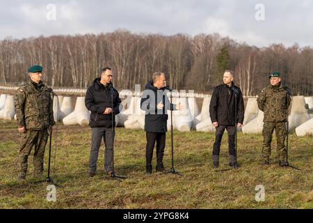 Da sinistra a destra: Gen. Marek Wawrzyniak, Ministro delle infrastrutture Dariusz Klimczak, primo Ministro Donald Tusk, Vice Ministro della difesa Nazionale Cezary Tomczyk, e col. Tomasz Sawczuk visti durante una conferenza stampa. Il primo ministro polacco Donald Tusk ha visitato la prima sezione completata dello "Scudo orientale" (polacco Tarcza Wschod), un'iniziativa di difesa nazionale lanciata per rafforzare i confini orientali della Polonia con la Bielorussia e l'exclave russa di Kaliningrad. Questo programma segna uno dei maggiori investimenti nella sicurezza nazionale e nella difesa delle frontiere nella storia del dopoguerra della Polonia. D Foto Stock