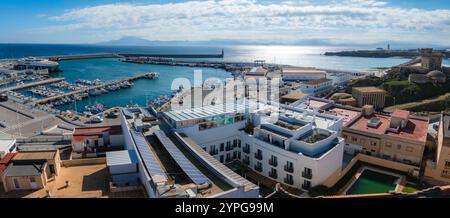 Vista aerea di Tarifa, Spagna, con un vivace porto con barche, il castello di Guzman el Bueno e l'architettura andalusa sotto un cielo limpido. Foto Stock