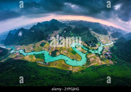 Vista aerea panoramica della valle di Phong Nam con risaie e tortuoso fiume attraverso un villaggio tradizionale nella campagna di Cao Bang, Vietnam Foto Stock