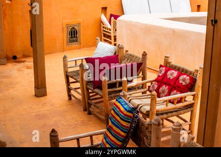 Sedie in legno con cuscini rossi e bianchi sul tetto di una lettura a Marakesh in Marocco Foto Stock