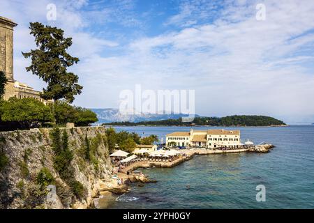 Vista dei bagni pubblici e della spiaggia di Faliraki con l'isola di Vido sullo sfondo, l'isola di Corfù, la Grecia Foto Stock