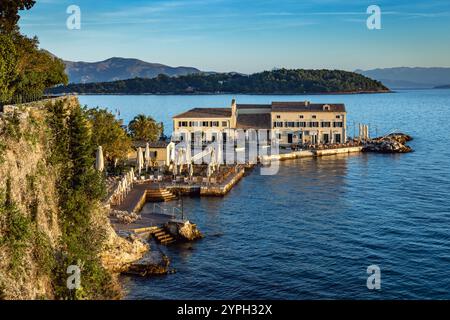 Vista dei bagni pubblici e della spiaggia di Faliraki con l'isola di Vido sullo sfondo dell'isola di Corfù, Grecia Foto Stock