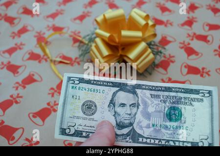 Pagare per un regalo con una banconota da un dollaro durante Natale Foto Stock