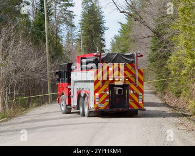 Camion dei pompieri che blocca una strada ghiaiosa. Rawdon, Quebec, Canada Foto Stock