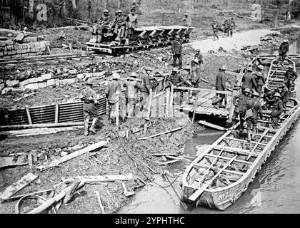 I britannici caricano barche da pontone con munizioni. Artiglieri reali britannici che caricano barche da pontone sul fiume scarpe con proiettili vicino a un motore della ferrovia leggera che passa sulla linea vicino a Saint-Laurent-Blangy, Francia, 1917 durante la Battaglia di Arras nella prima guerra mondiale Foto Stock