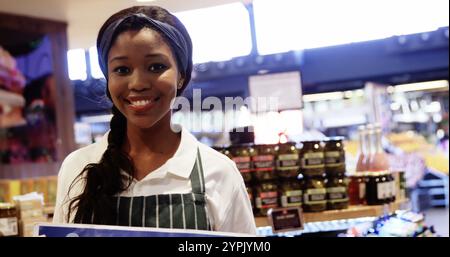 Ritratto del personale femminile che tiene un cartello aperto nella sezione organica del supermercato Foto Stock