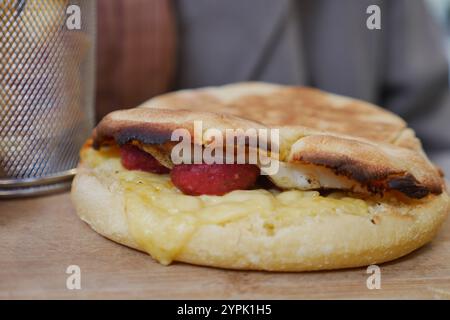 Si tratta di un delizioso sandwich per la colazione ripieno di uova, formaggio e salsiccia Foto Stock