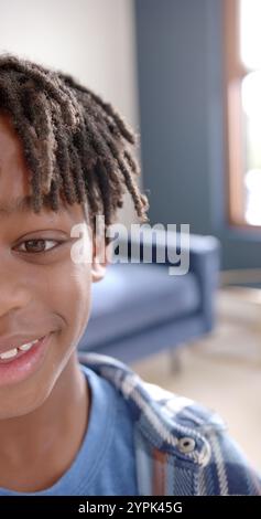 Immagine verticale del ritratto di un ragazzo afroamericano felice sorridente a casa Foto Stock