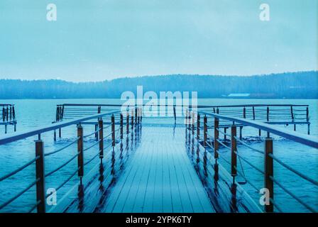 Una scena tranquilla cattura la nebbia che si libra su un lago e sulle montagne Foto Stock