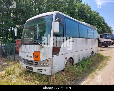 vecchio scuolabus turchese di isuzu, caduto fuori uso, seduto su un terreno di rifiuti industriali nella contea di zala in ungheria Foto Stock