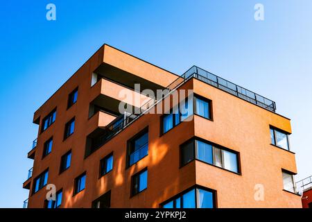 Vivace angolo degli edifici con facciata rossa e gialla a contrasto e finestre riflettenti Foto Stock