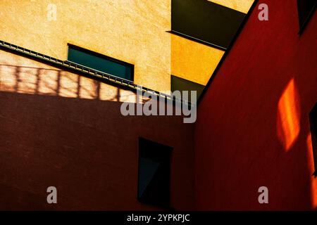 Vivace angolo degli edifici con facciata rossa e gialla a contrasto e finestre riflettenti Foto Stock