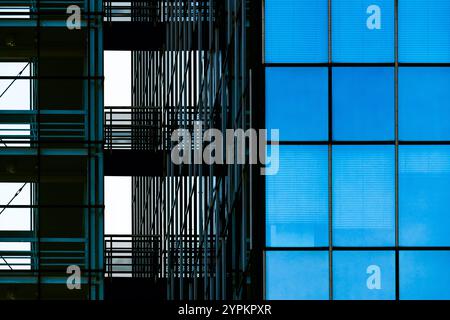 Moderna facciata in vetro con scale interne con motivi simmetrici e riflessi Foto Stock