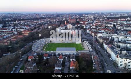 München, Deutschland, 30. Novembre 2024: Hier der Blick in München auf die Skyline, Häuser, Häusermeer vom Stadtteil Giesing, sowie das Städtische Stadion an der Grünwalder Strasse, Grünwalderstadion, Fussballstadion in der Dämmerung Bild darf nur Redaktionell genutzt werden *** Monaco di Baviera, Germania, 30 novembre 2024 Ecco la vista a Monaco di Baviera dello skyline, case, mare delle case del quartiere Giesing, nonché dello stadio municipale Grünwalder Grünwalderstadion, può essere utilizzato solo per la stampa Foto Stock