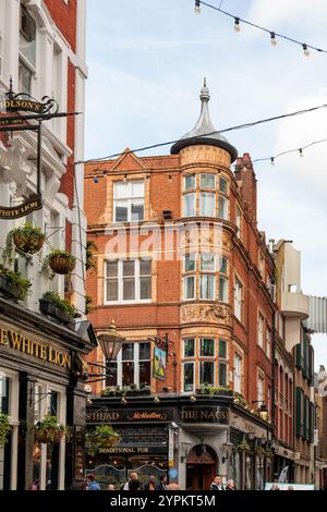 Storici pub White Lion e Nags Head in un edificio vittoriano in mattoni rossi con torretta ornata e finestre a bovindo, Covent Garden, Londra Foto Stock
