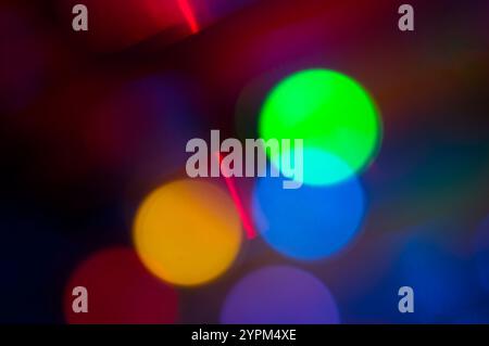 Sfere luminose sovrapposte in giallo, arancione, blu e rosso su sfondo scuro Foto Stock
