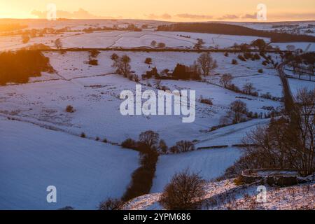 Il sole tramonta su una scena innevata a Crowdecote, nella parte superiore della dove Valley, nel Peak District National Park, nel Derbyshire/Stafordshire Foto Stock