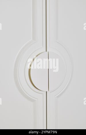 Un elegante design bianco dello sportello con un'elegante maniglia circolare che migliora qualsiasi spazio Foto Stock