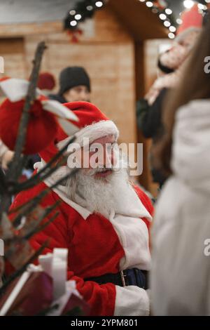 Vecchio Babbo Natale con cappello seduto al mercatino di Natale di Sofia, Bulgaria. Foto Stock