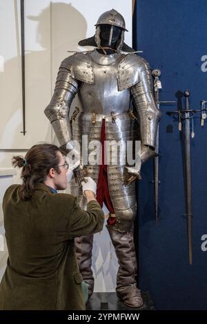 Londra, Regno Unito. Dicembre 2024. Un membro dello staff presenta Una raffinata e importante corazzatura corazzata a tre quarti dell'Italia settentrionale, circa 1620-30, stimata tra £ 25.000 e £ 35.000, in anteprima della vendita di armi, armature e militari d'epoca alle aste Olympia di Kensington Olympia. I lotti saranno venduti il 4 dicembre. Crediti: Stephen Chung / Alamy Live News Foto Stock