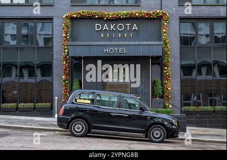 Taxi elettrico in attesa all'ingresso di un Dakota Hotel, West Regent Street, Glasgow, Scozia, Regno Unito, Europa Foto Stock