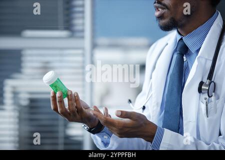 Vista laterale primo piano di mani maschili che trattengono il flacone di prescrizione verde e danno al paziente in clinica, spazio di copia Foto Stock