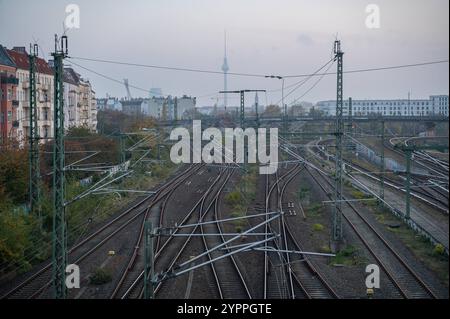 09.11.2024, Berlino, Deutschland, Europa - Ein erhoehter Blick von der Boesebruecke entlang der Bornholmer Strasse ueber Bahngleise in Richtung Berlin-Mitte mit dem Berliner Fernsehturm am Alexanderplatz in der Ferne. Heute, vor 35 Jahren, 9. Novembre 1989, fiel die Berliner Mauer und der ehemalige Grenzuebergang an der Bornholmer Strasse zwischen den Bezirken Prenzlauer Berg und Wedding War der erste, an dem DDR-Buerger aus Ost-Berlin nach West-Berlin stroemten. *** 09 11 2024, Berlino, Germania, Europa una vista elevata dal Boesebruecke lungo Bornholmer Strasse sui binari ferroviari towar Foto Stock