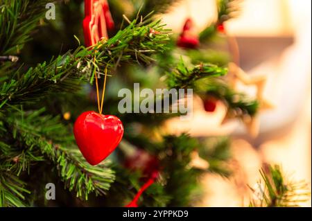 Decorazione a forma di cuore rosso su un albero di Natale, dettaglio Foto Stock