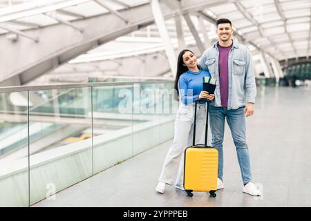 Coppia felice in preparazione per una vacanza emozionante all'aeroporto Foto Stock