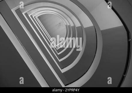 Immagine in bianco e nero che mostra una scala a spirale astratta con un motivo geometrico. Foto Stock