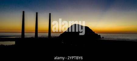 25 GENNAIO 2020 - MORRO BAY, CALIFORNIA, Stati Uniti - tramonto su Morro Rock a Morro Bay con motore in primo piano e tre fumogeni Foto Stock
