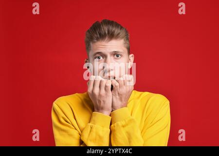 Studente emotivo che ha stress prima dell'esame su sfondo rosso Foto Stock