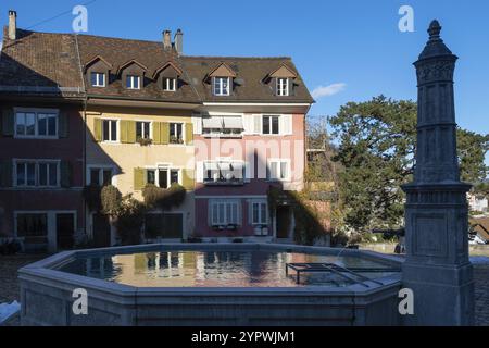 Centro storico di Brugg AG, Svizzera. La fontana e gli edifici medievali alla luce del sole del tardo pomeriggio Foto Stock