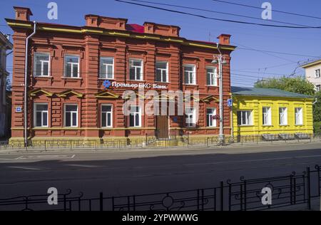 Irkutsk, Russia, 28 agosto 2021: Due vecchie case dipinte di rosso brillante e giallo si trovano una accanto all'altra. Irkutsk, Lenin Street. Giornata di sole Foto Stock