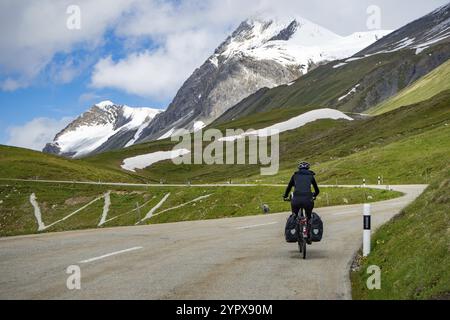 Situazione sulla strada del passo di Albula in Engadina, Grigioni, Svizzera, in una bella mattinata d'estate. Un ciclista che sale il passo. Vista lungo la strada per Foto Stock