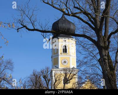 La famosa torre gialla della chiesa del monastero di Bernried, Baviera, Germania, dietro un albero e di fronte al cielo blu dell'Europa Foto Stock