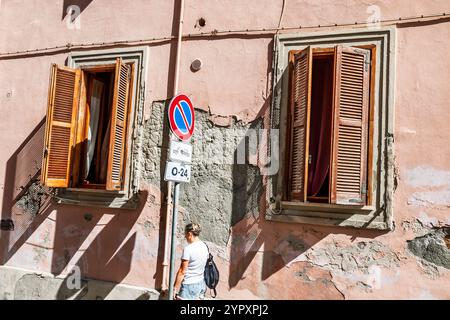 Civitavecchia, via dell'Orazione, parete esterna, persiane in legno, finestre aperte, facciata in gesso incrinato, cartello di divieto di parcheggio, cartello n. 0-24, bui rosa Foto Stock