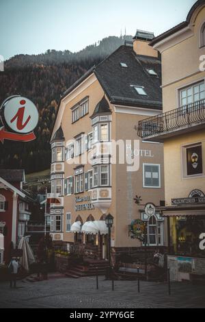 11/03/2024 - Moody Street Scene a Ortisei, Italia: Tranquilla città alpina catturata con tenui toni freddi che creano un'atmosfera suggestiva e pittoresca Foto Stock